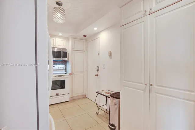 a view of kitchen with refrigerator cabinets and stove top oven