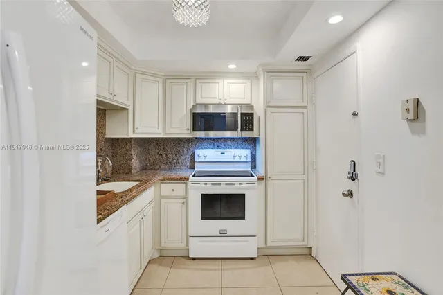 a kitchen with stainless steel appliances granite countertop a stove a microwave and a refrigerator