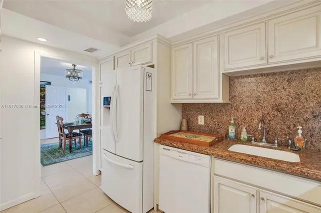 a kitchen with stainless steel appliances granite countertop white cabinets and a refrigerator