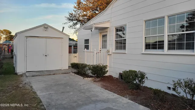 a view of a house with a yard and potted plants