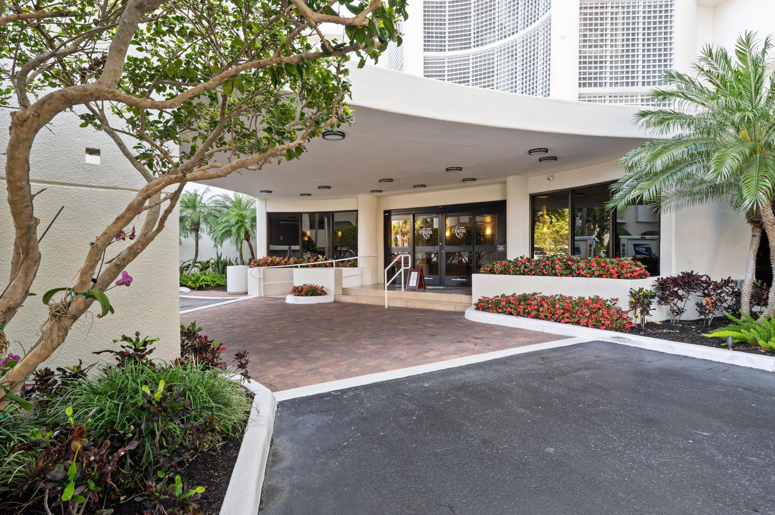 3000 North Ocean Drive, Unit 40E Riviera Beach, FL 33404 - Photo 13 of 50 a view of a patio with table and chairs potted plants and large tree