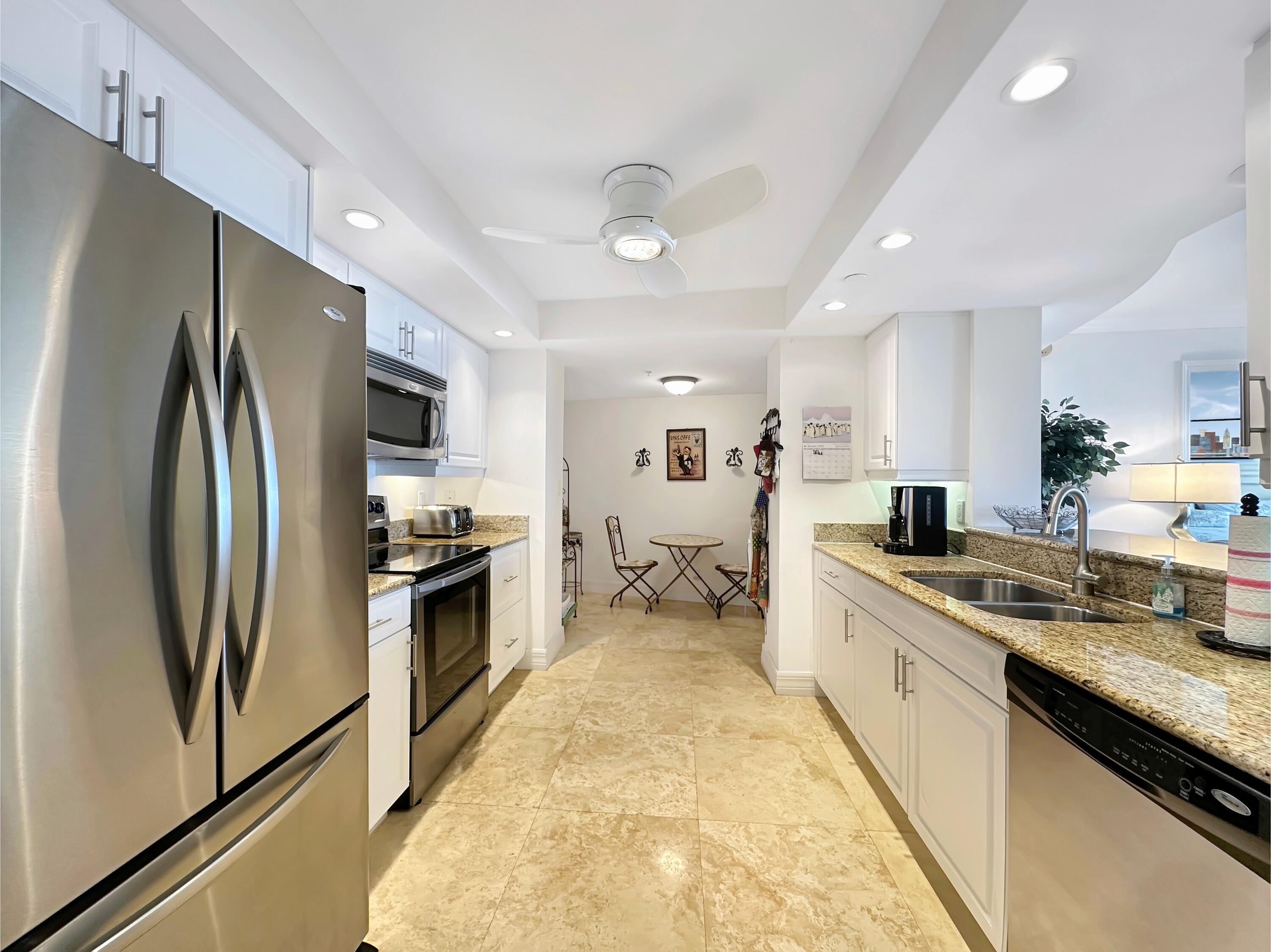 3000 North Ocean Drive, Unit 40E Riviera Beach, FL 33404 - Photo 5 of 50 a large kitchen with stainless steel appliances granite countertop a stove refrigerator and a sink