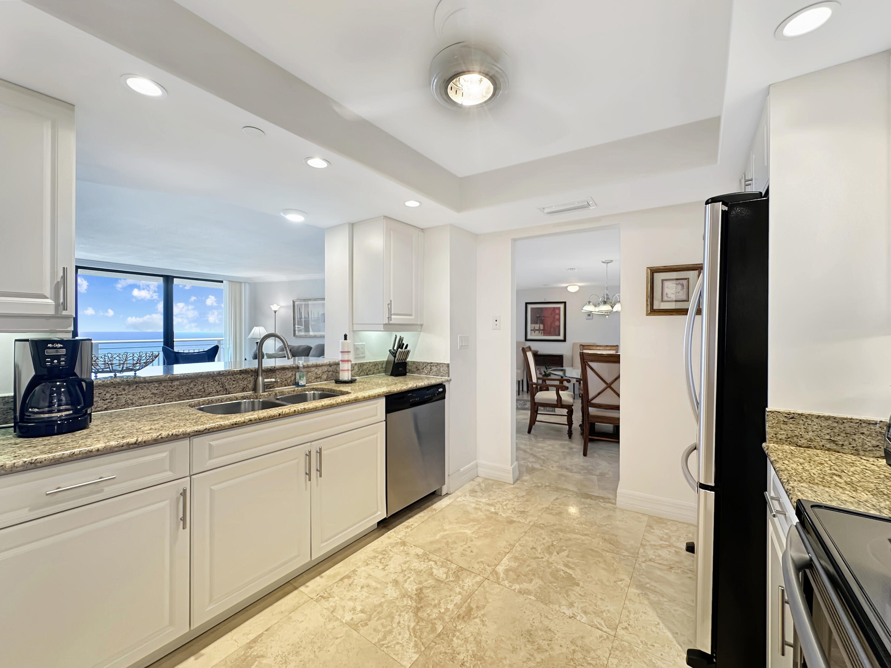 3000 North Ocean Drive, Unit 40E Riviera Beach, FL 33404 - Photo 6 of 50 a kitchen with stainless steel appliances granite countertop a refrigerator and a sink