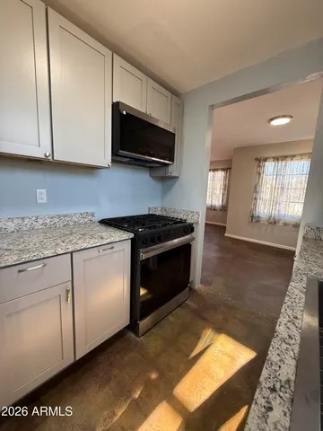 a kitchen with stainless steel appliances granite countertop a stove a sink and a microwave