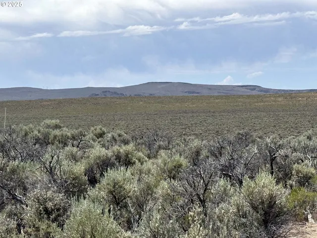 a view of mountain with sunset in background