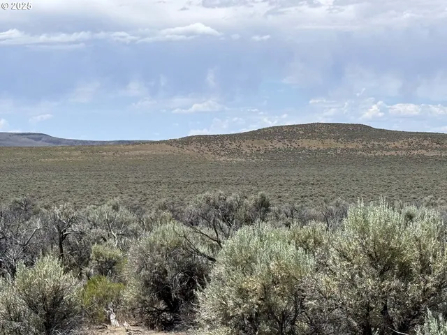 a view of mountain with sunset in background
