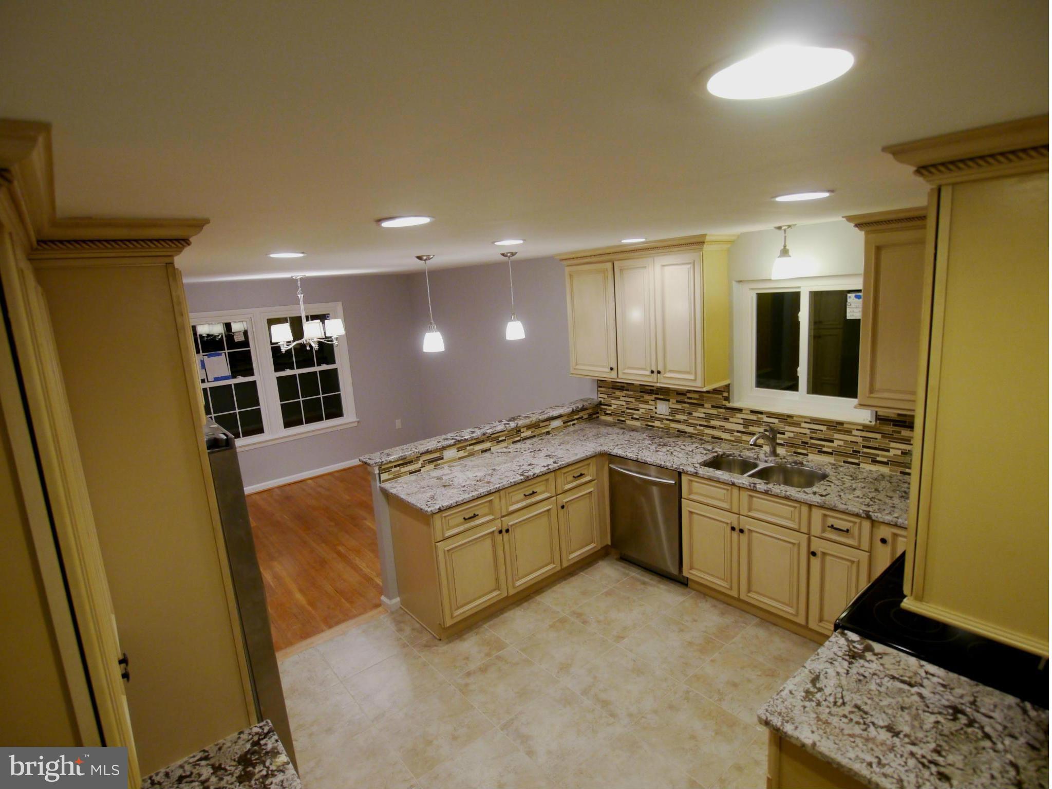 13100 Middlevale Lane Silver Spring, MD 20906 - Photo 11 of 30 a large kitchen with stainless steel appliances granite countertop a stove and a refrigerator