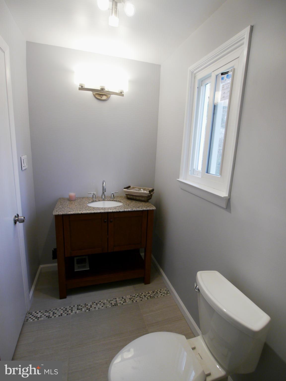 13100 Middlevale Lane Silver Spring, MD 20906 - Photo 20 of 30 a bathroom with a toilet a sink and mirror
