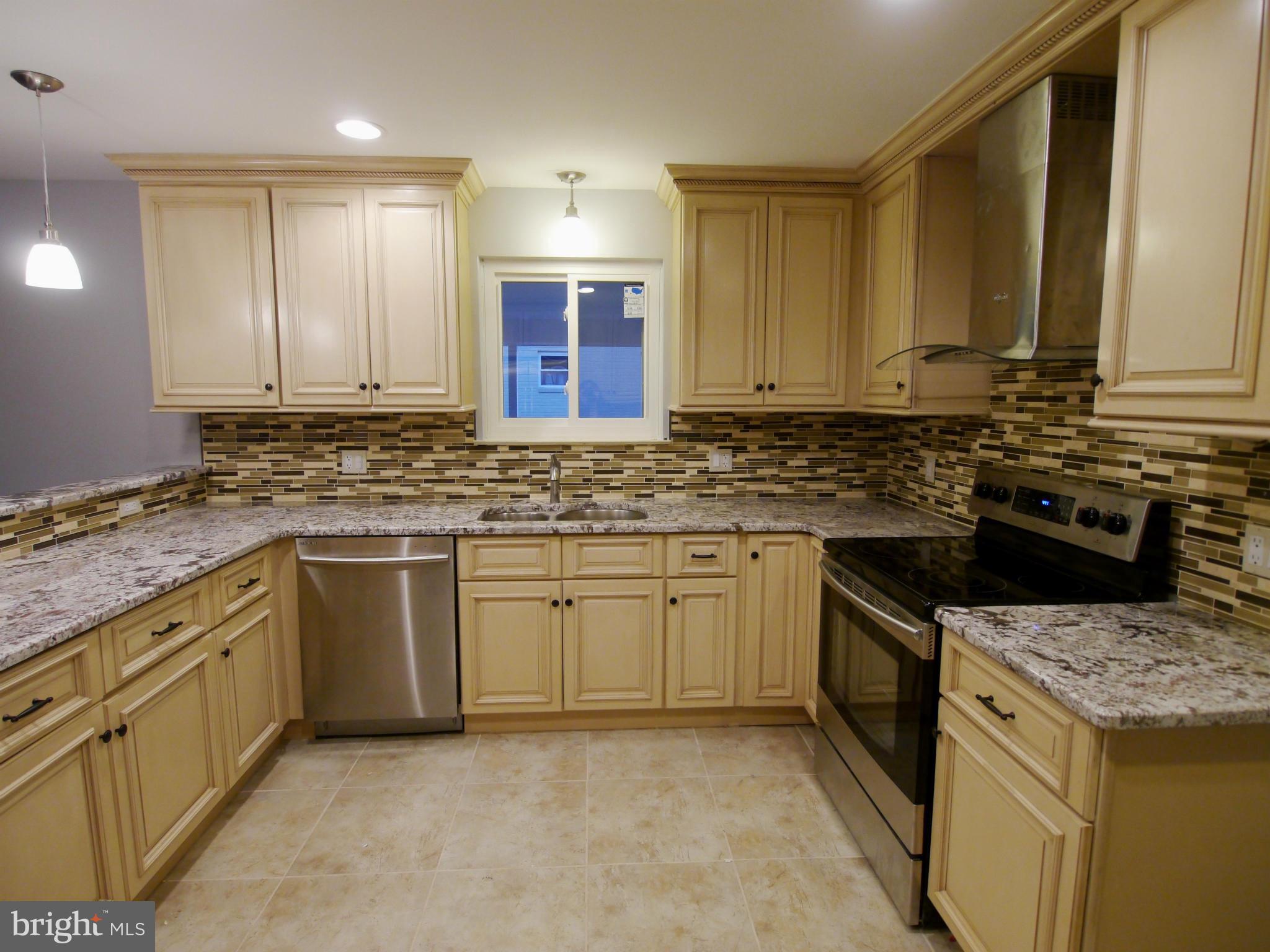 13100 Middlevale Lane Silver Spring, MD 20906 - Photo 3 of 30 a kitchen with granite countertop a sink stainless steel appliances and cabinets