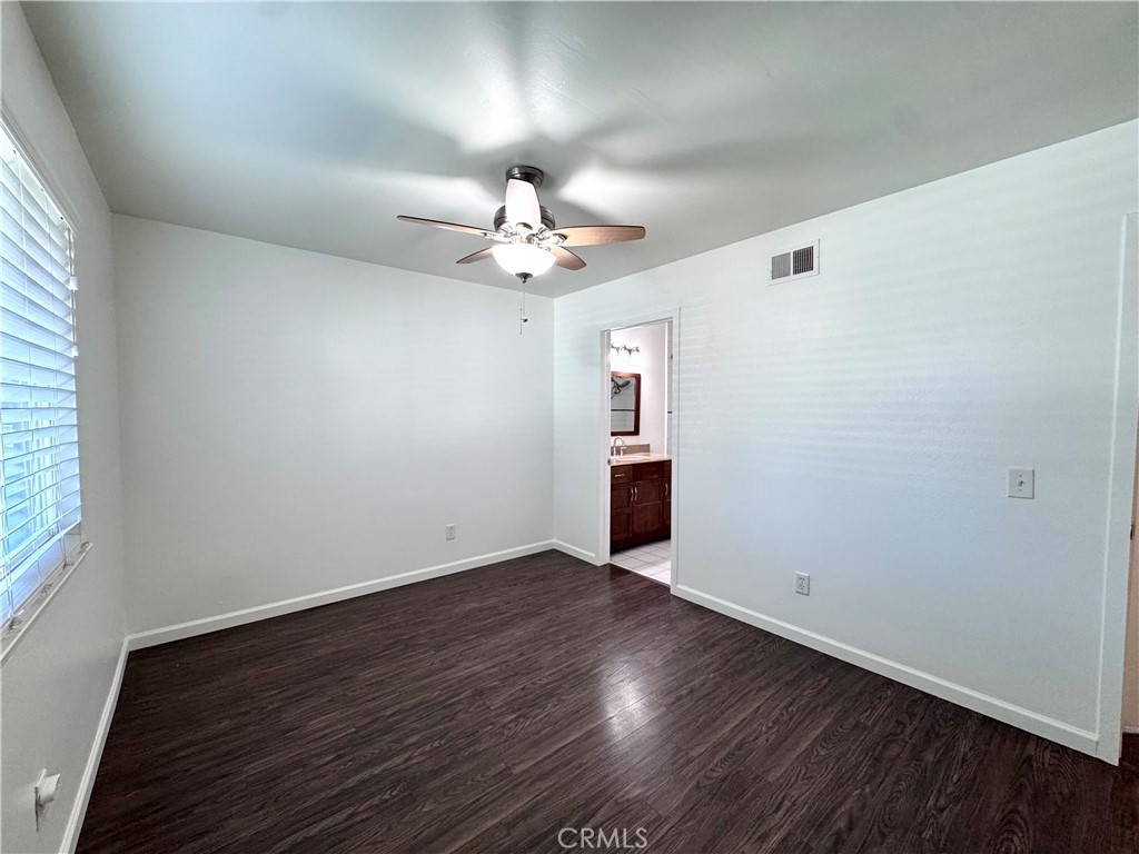 4692 Heil Avenue Huntington Beach, CA 92649 - Photo 12 of 27 an empty room with wooden floor chandelier fan and windows