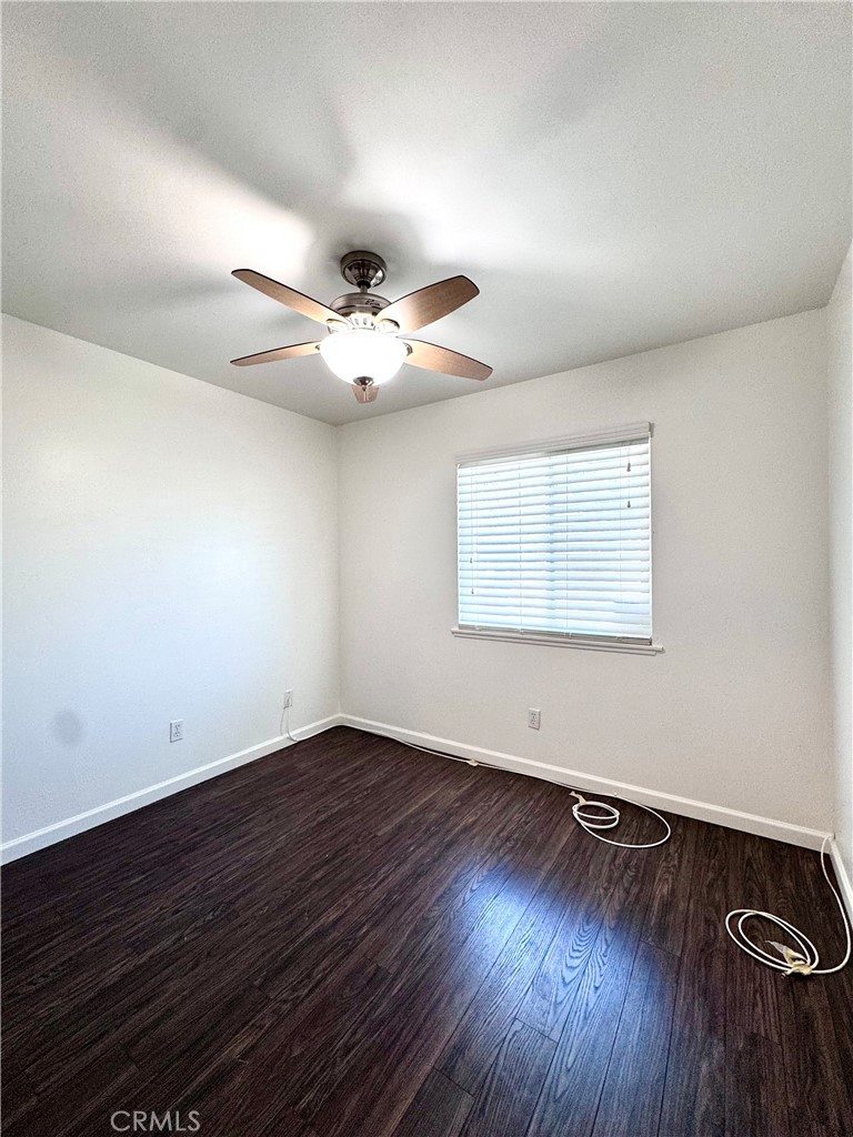 4692 Heil Avenue Huntington Beach, CA 92649 - Photo 15 of 27 a view of an empty room with wooden floor and a ceiling fan