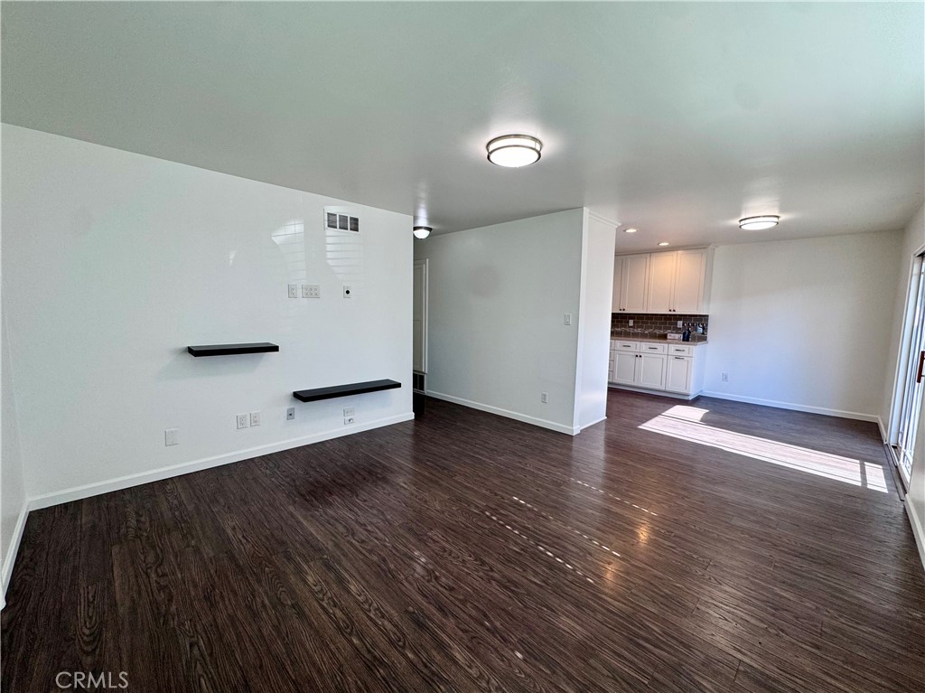 4692 Heil Avenue Huntington Beach, CA 92649 - Photo 2 of 27 an empty room with wooden floor and a kitchen