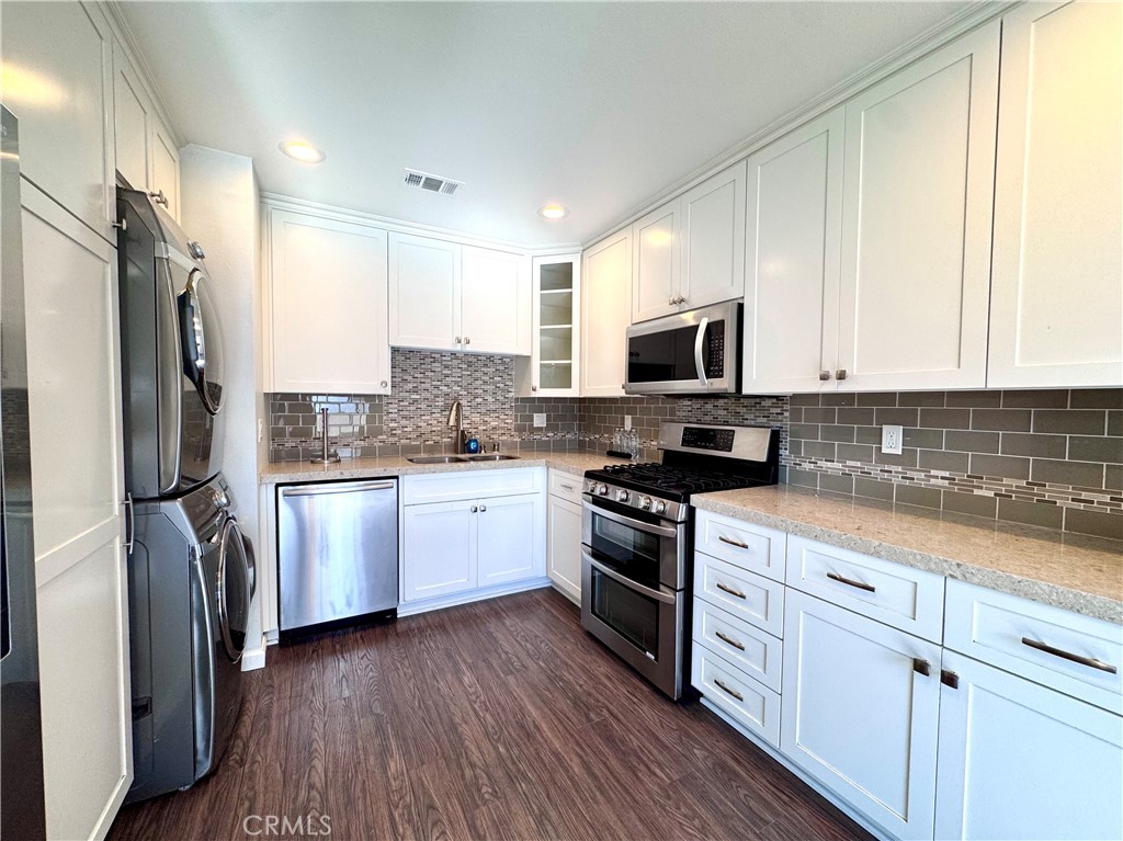 4692 Heil Avenue Huntington Beach, CA 92649 - Photo 4 of 27 a kitchen with granite countertop a refrigerator stove and microwave