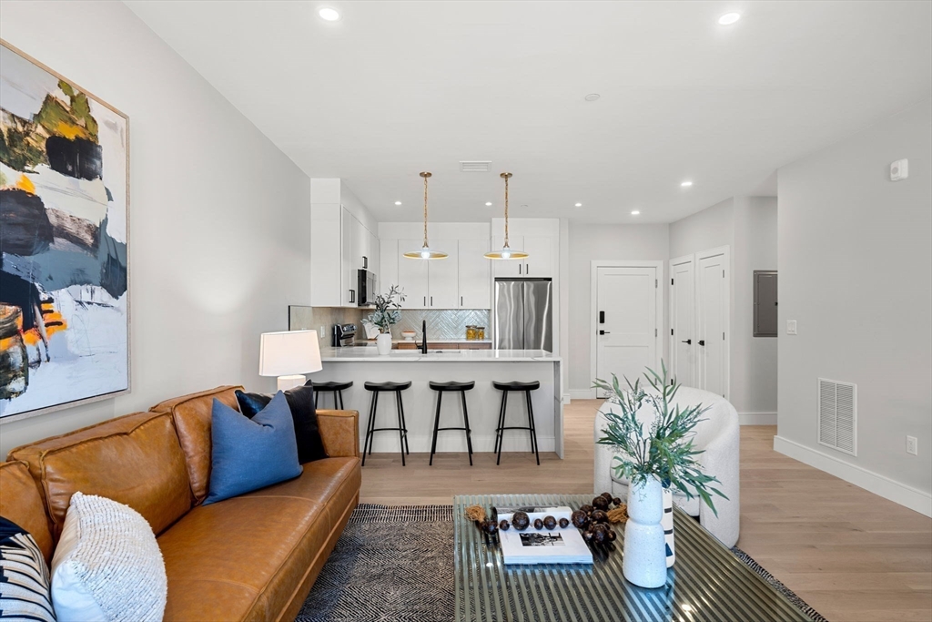 a living room with furniture kitchen view and a potted plant