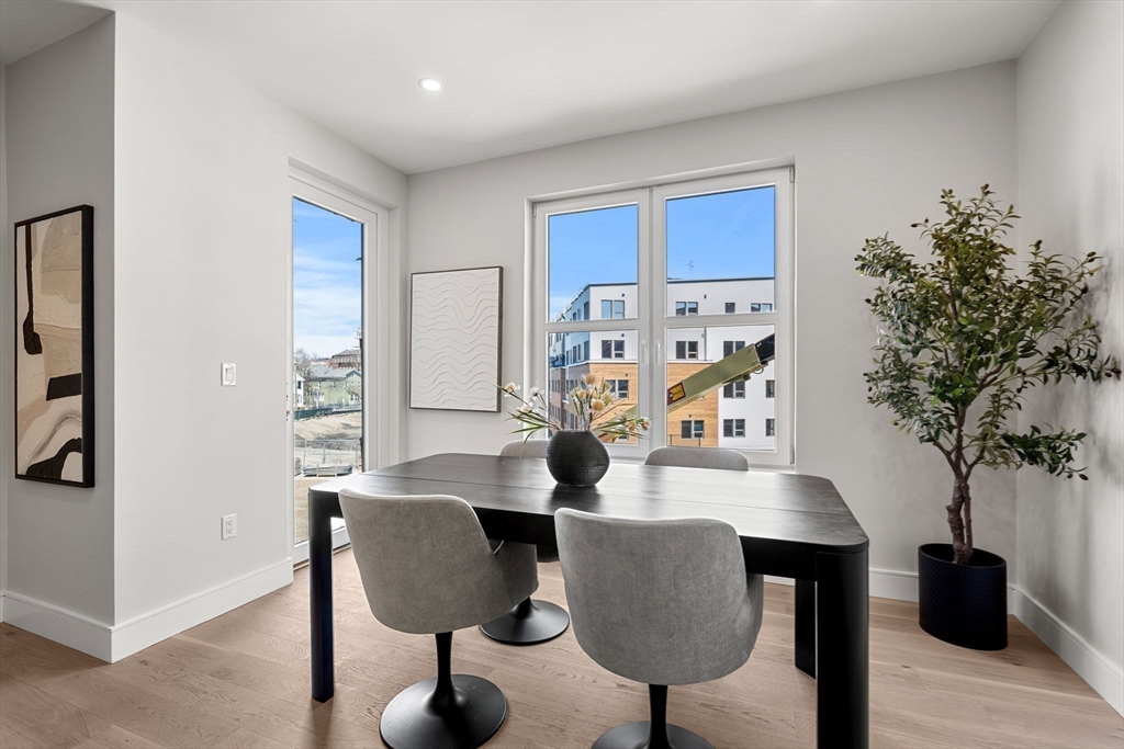27 Guild Street, Unit 102 Boston, MA 02119 - Photo 11 of 29 a dining room with furniture and wooden floor