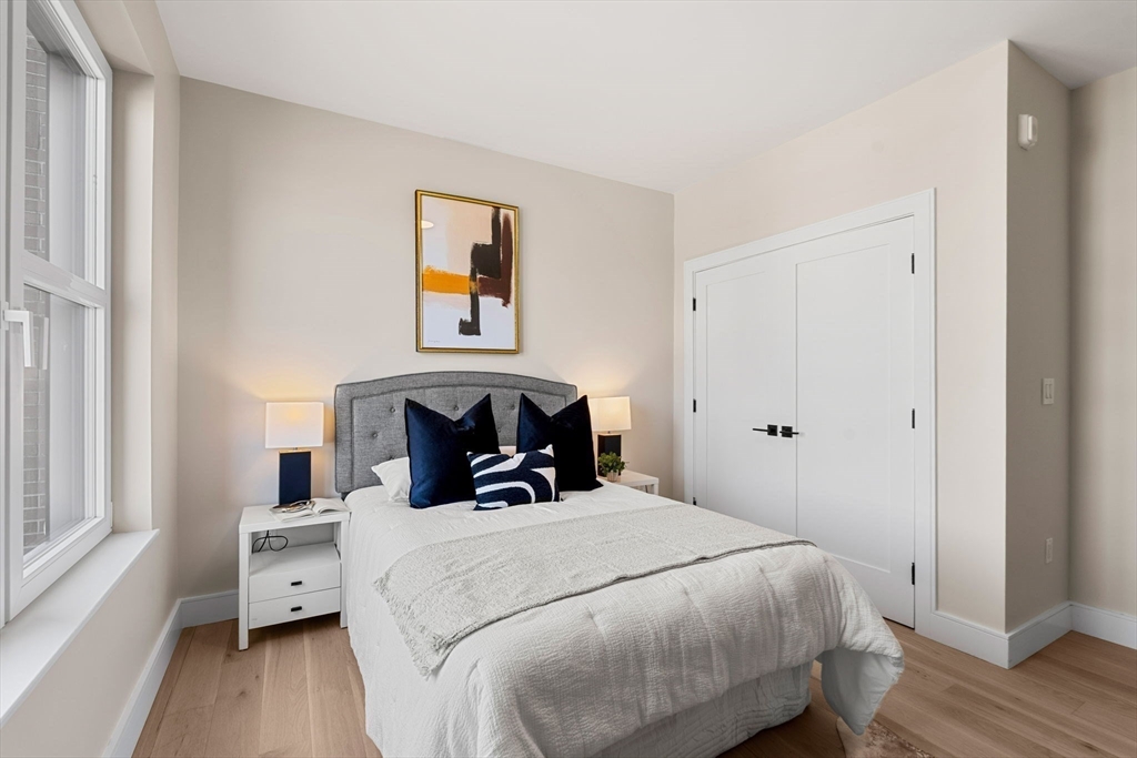 27 Guild Street, Unit 102 Boston, MA 02119 - Photo 20 of 29 a bedroom with a bed and wooden floor