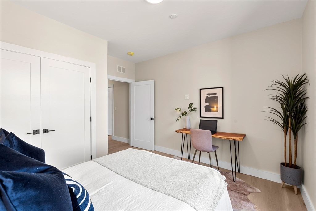 27 Guild Street, Unit 102 Boston, MA 02119 - Photo 21 of 29 a bedroom with a bed and a potted plant