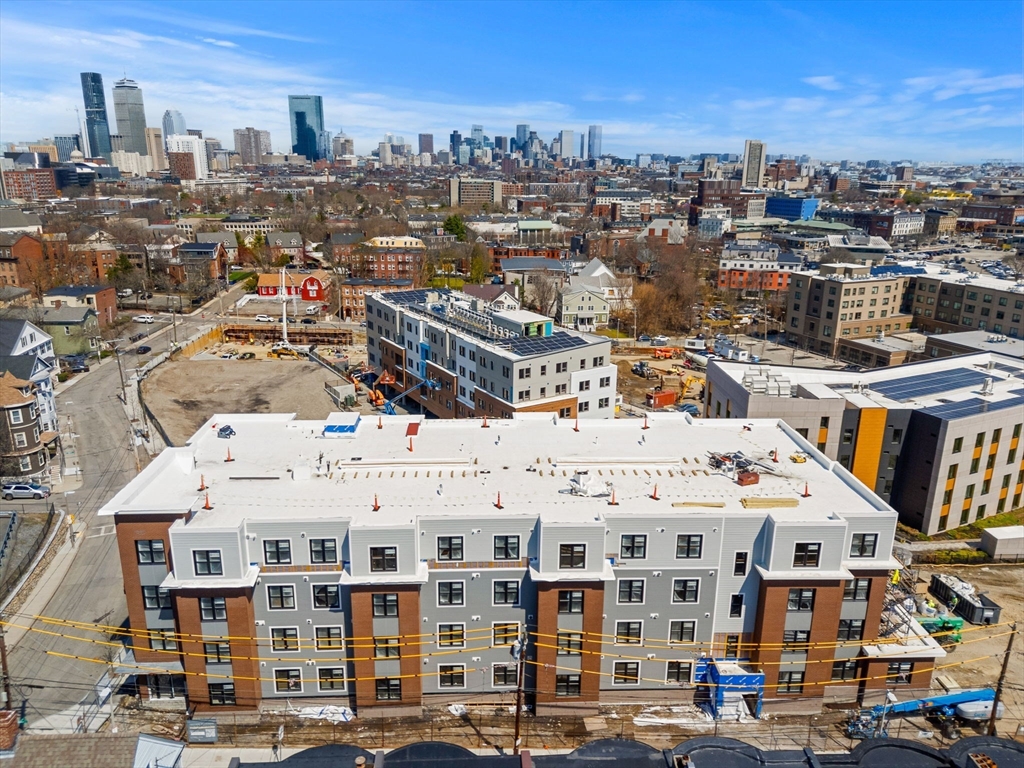 27 Guild Street, Unit 102 Boston, MA 02119 - Photo 29 of 29 a large building with a city view