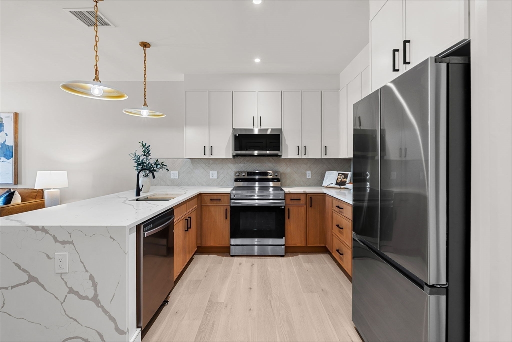 27 Guild Street, Unit 102 Boston, MA 02119 - Photo 8 of 29 a kitchen with a stove and a refrigerator
