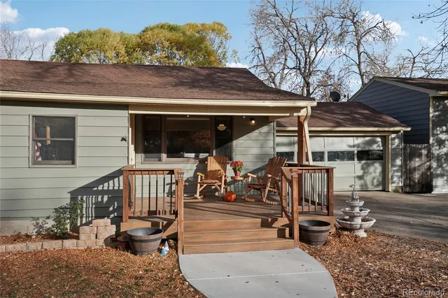 a view of a patio with table and chairs with wooden floor and fence