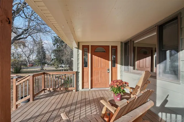 a balcony with wooden floor table and chairs