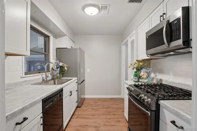 a kitchen with stainless steel appliances kitchen island granite countertop a sink stove and microwave