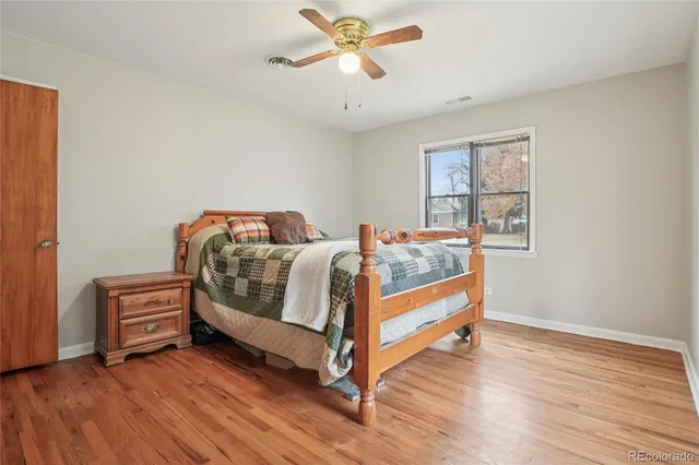 a bedroom with a bed and a chandelier fan