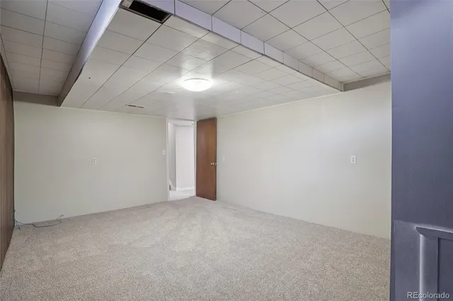 a view of a house with a yard and large tree