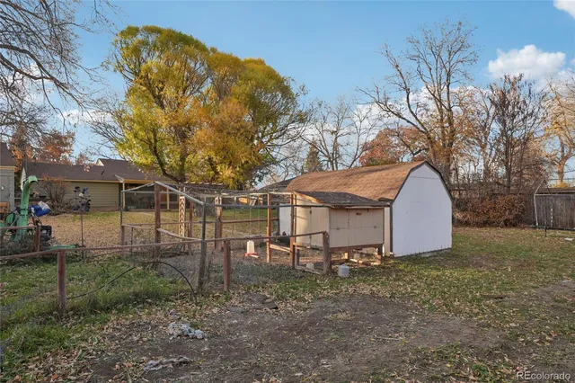 a view of a house with backyard and trees