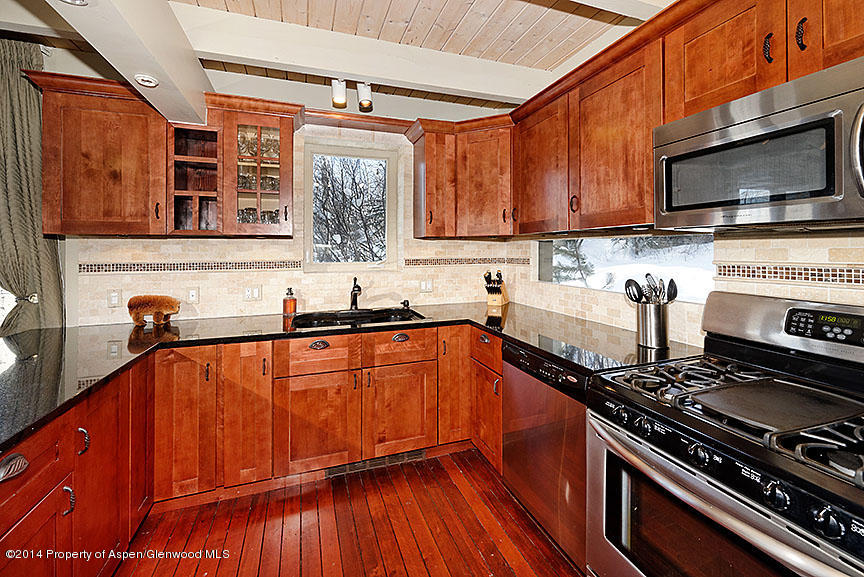 47 North Ridge Lane, Unit B Snowmass Village, CO 81615 - Photo 6 of 18 a kitchen with stainless steel appliances granite countertop a stove a sink and a microwave