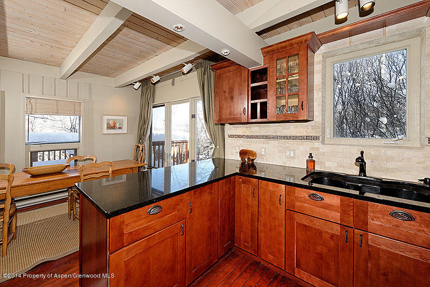 47 North Ridge Lane, Unit B Snowmass Village, CO 81615 - Photo 7 of 18 a kitchen with granite countertop a sink and cabinets