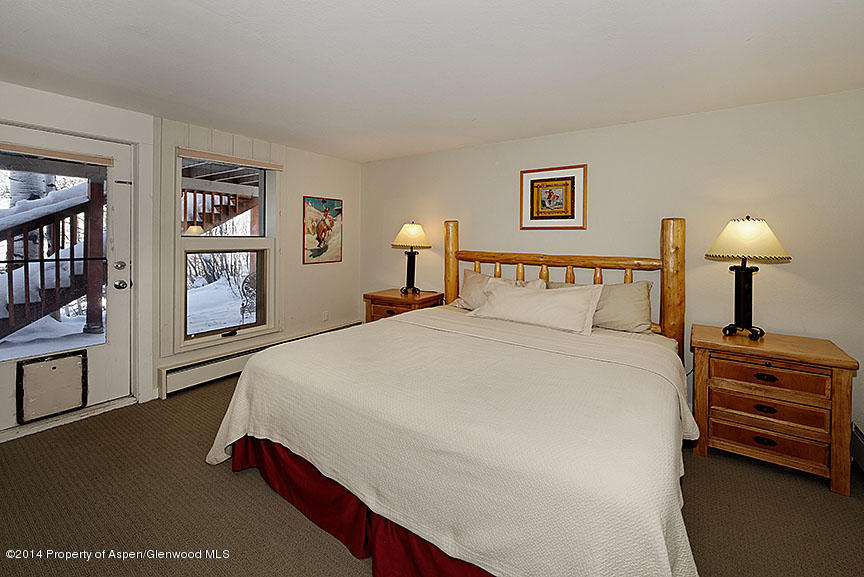 47 North Ridge Lane, Unit B Snowmass Village, CO 81615 - Photo 10 of 18 a bedroom with a bed and a lamp on dresser