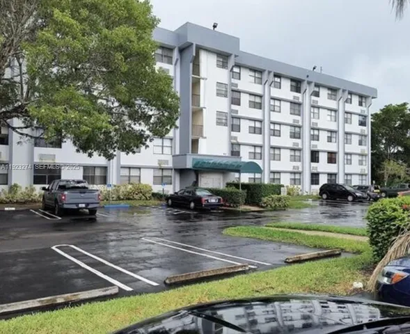 a front view of a building with lot of cars parked