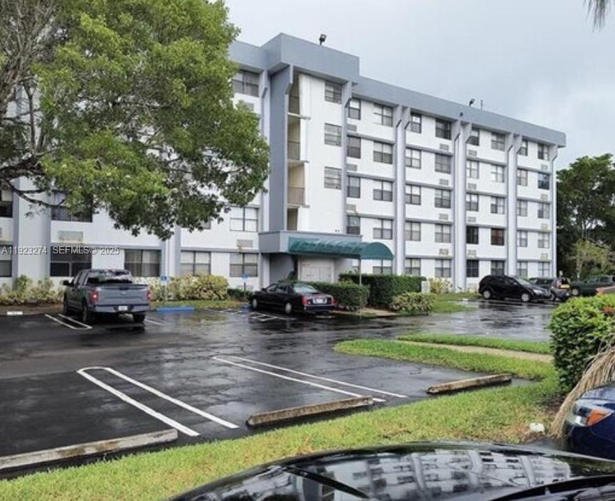 2501 Riverside Drive, Unit 402A Coral Springs, FL 33065 - Photo 1 of 9 a front view of a building with lot of cars parked