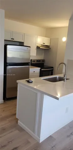 a kitchen with a sink and a refrigerator