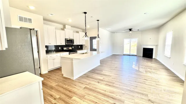 a large kitchen with cabinets a sink and a stove top oven
