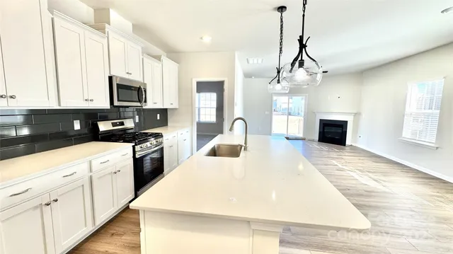 a kitchen with a stove a sink a refrigerator and a center island