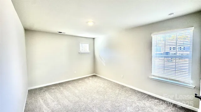 a view of an empty room with a fireplace and a window