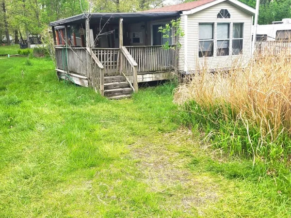 a view of a house with a yard and wooden deck