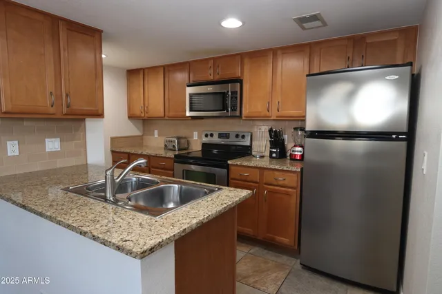 a kitchen with a refrigerator sink and cabinets