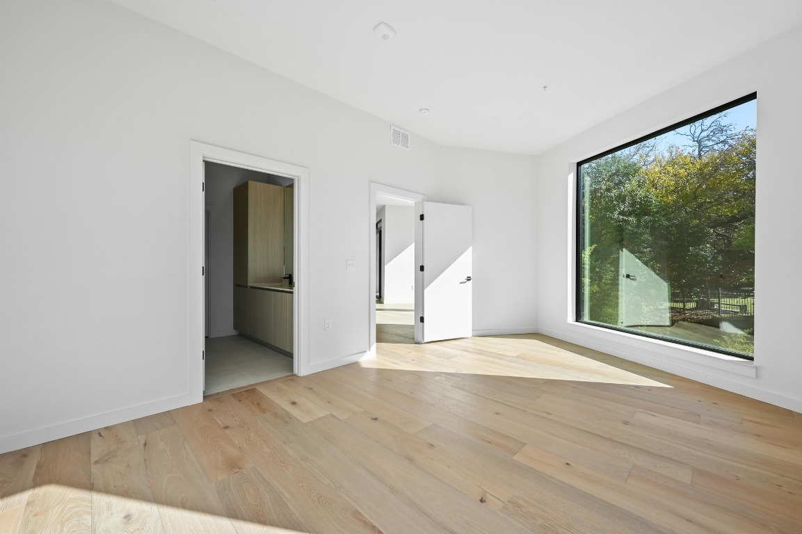 2209 South 1st Street, Unit 114 Austin, TX 78704 - Photo 12 of 27 a view of an empty room with a window and wooden floor
