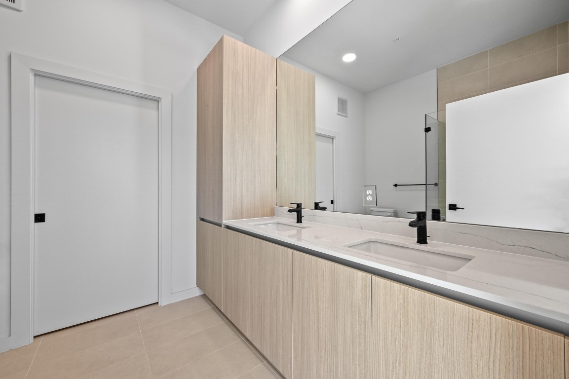 2209 South 1st Street, Unit 114 Austin, TX 78704 - Photo 13 of 27 a bathroom with a double vanity sink and a mirror