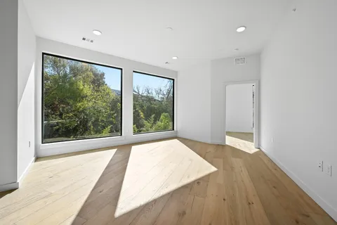 a view of a room with wooden floor and a balcony