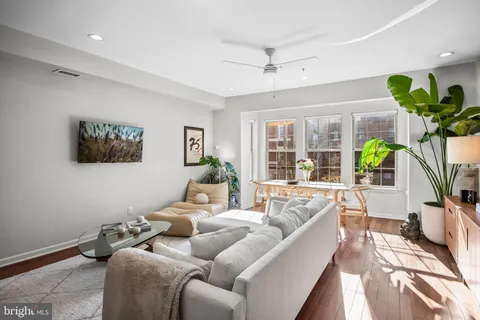 a living room with furniture a chandelier and a wooden floor