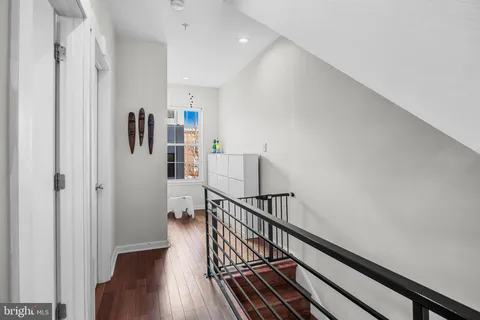 a view of a hallway with wooden floor and stairs