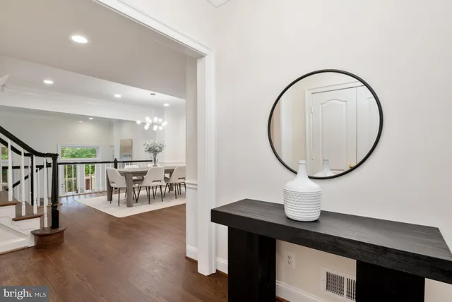 a living room with furniture a mirror and a potted plant