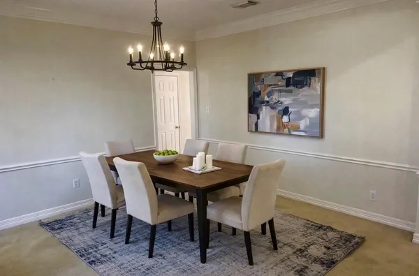 a view of a dining room with a table and chairs