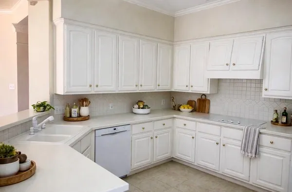 a kitchen with white cabinets and sink