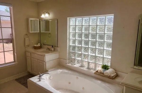 a bathroom with a tub sink and window