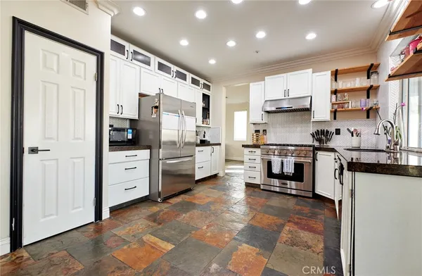 a kitchen with stainless steel appliances a refrigerator sink and cabinets